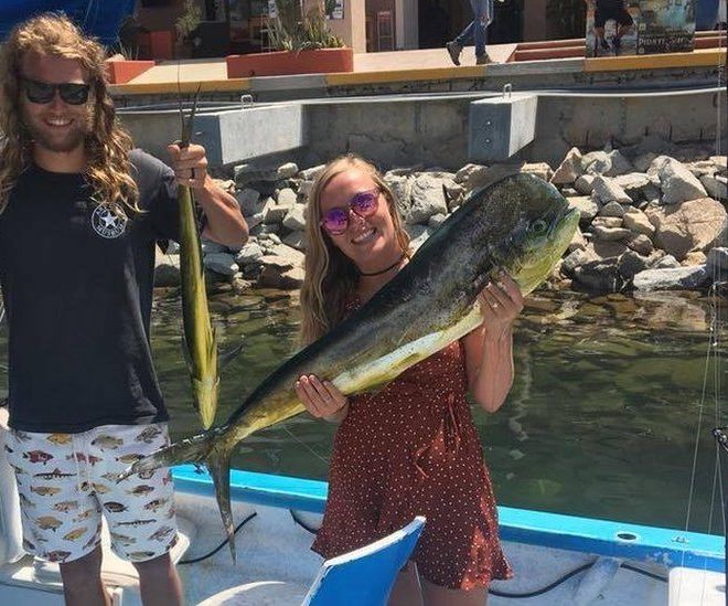Chynna Deese and Lucas Fowler holding fish on a boat