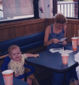 Corina Boyd as a baby with her mother, Rhonda Rosenbalm, sitting at a table. Courtesy: Corina Boyd